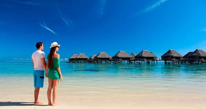 Guests walk along the beach